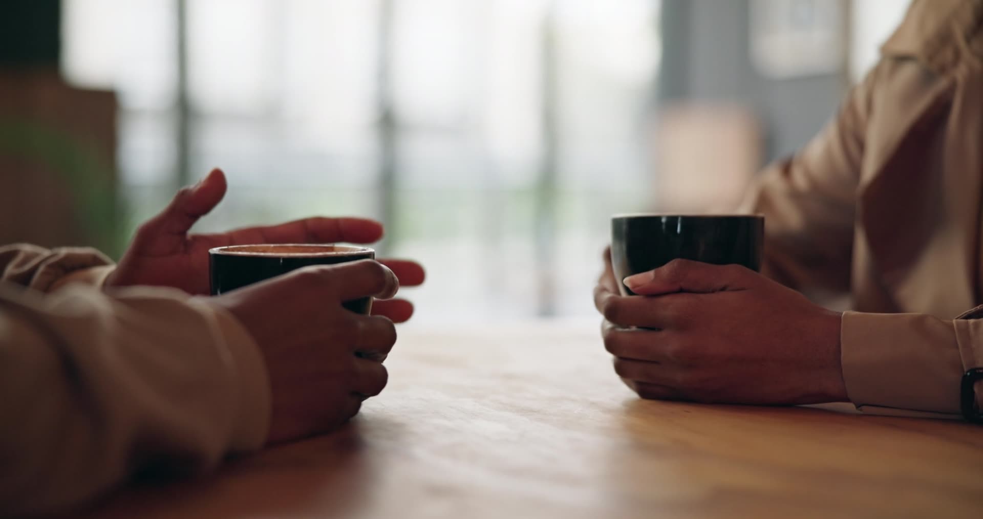 Two people having a conversation over coffee